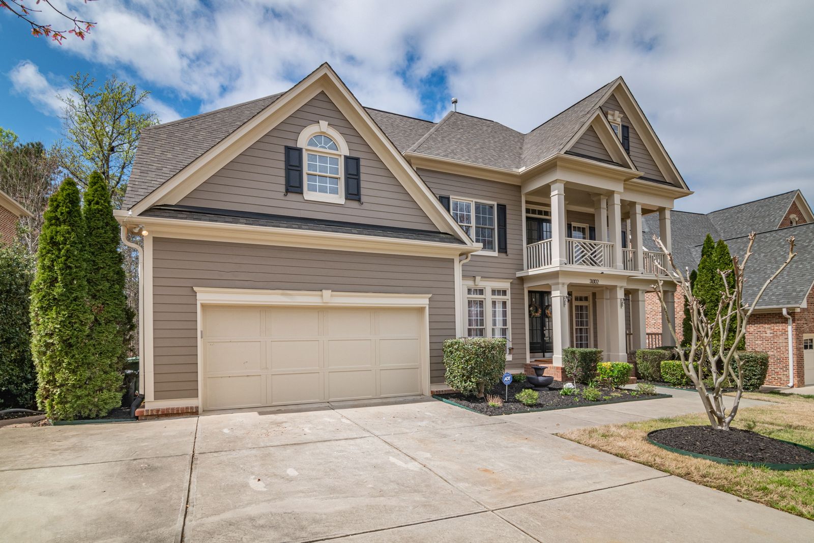 Two-story home with a columned porch, shingle roof and painted siding